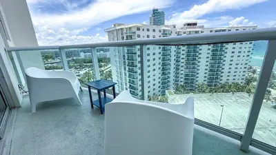 a balcony with white chairs and a table and a building at THE TIDES 2bedrooms apt 14th floor WE ARE ON THE BEACH! in Hollywood