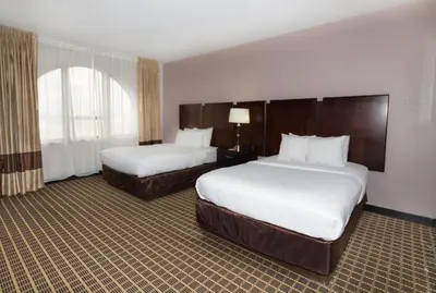 a hotel room with two beds and a window at Clarion Inn & Suites Miami International Airport in Miami
