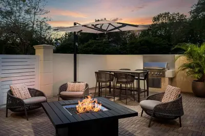 a patio with a table and chairs and a fire pit at Residence Inn by Marriott Miami Aventura Mall in Aventura