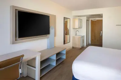 a bedroom with a bed and a flat screen tv at Hotel Dello Ft Lauderdale Airport, Tapestry Collection by Hilton in Dania Beach