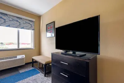 a living room with a flat screen tv on a dresser at Cambria Hotel Ft Lauderdale, Airport South & Cruise Port in Dania Beach