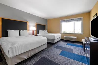 a hotel room with two beds and a window at Cambria Hotel Ft Lauderdale, Airport South & Cruise Port in Dania Beach