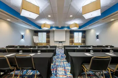 a conference room with tables and chairs and a podium at Cambria Hotel Ft Lauderdale, Airport South & Cruise Port in Dania Beach