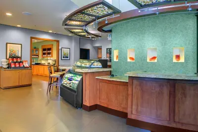 a restaurant with a counter and a bar at Hyatt Place Fort Lauderdale Airport/Cruise Port in Dania Beach