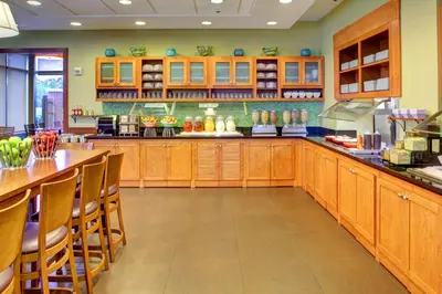 a large kitchen with wooden cabinets and a bar at Hyatt Place Fort Lauderdale Airport/Cruise Port in Dania Beach