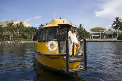 a yellow boat in the water with two people on it at Hyatt Place Fort Lauderdale Airport/Cruise Port in Dania Beach