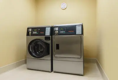 a washer and dryer in a room with a clock at Hyatt Place Fort Lauderdale Airport/Cruise Port in Dania Beach