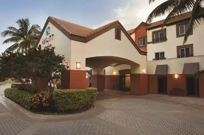 a building with a palm tree in front of it at Hyatt House Miami Airport in Miami