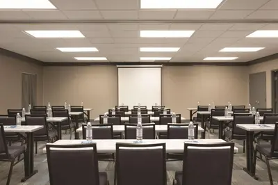 a conference room with tables and chairs and a whiteboard at Hyatt House Miami Airport in Miami