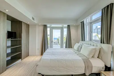 a bedroom with a large bed with a large window at Modern Ocean Drive Condo in the Heart of Sobe! in Miami Beach