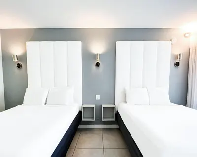 two beds in a room with white pillows at Royal Palms Resort & Spa in Fort Lauderdale