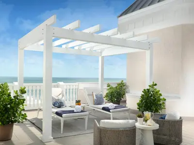 a white pergola on a patio overlooking the ocean at Pelican Grand Beach Resort, a Noble House Resort in Fort Lauderdale