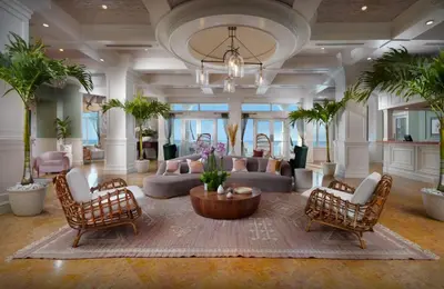 a lobby with a couch and a table and chairs at Pelican Grand Beach Resort, a Noble House Resort in Fort Lauderdale