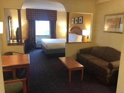 a hotel room with a bed and a couch at Holiday Inn Express and Suites Fort Lauderdale Airport West by IHG in Davie