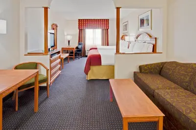 a hotel room with a bed and a couch at Holiday Inn Express and Suites Fort Lauderdale Airport West by IHG in Davie