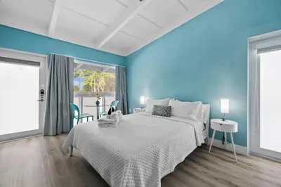 a bedroom with a large bed and blue walls at The New Yorker Hotel Miami in Miami