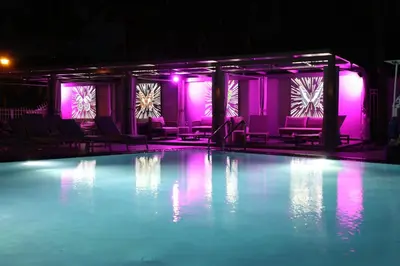 a swimming pool with purple lights and chairs at The Sagamore Hotel South Beach in Miami Beach