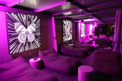 a purple room with couches and tables and chairs at The Sagamore Hotel South Beach in Miami Beach