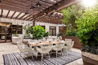 an outdoor patio with a wooden table and chairs at The Ritz-Carlton Coconut Grove, Miami in Miami