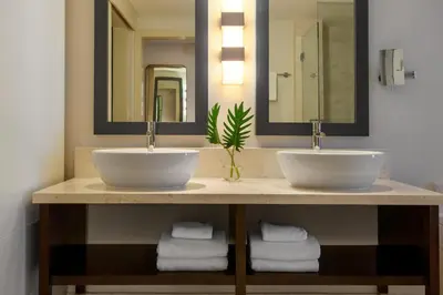 a bathroom with two sinks and two mirrors at Kimpton EPIC Hotel by IHG in Miami