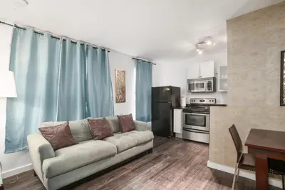 a living room with a couch and a kitchen at Apartment On The Beach in Miami Beach