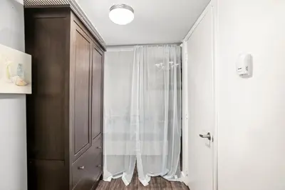 a bathroom with a shower curtain and a cabinet at Apartment On The Beach in Miami Beach