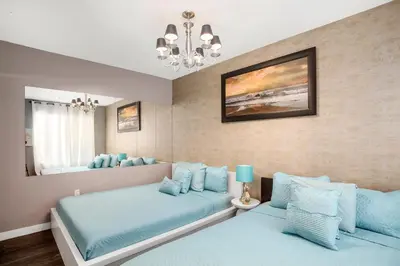a bedroom with two beds and a mirror at Apartment On The Beach in Miami Beach