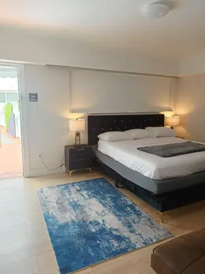 a bedroom with a bed and a blue rug at Pousada Suites at Hollywood Beach in Hollywood