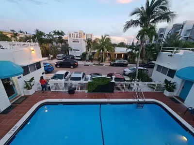 a pool in front of a parking lot at Pousada Suites at Hollywood Beach in Hollywood
