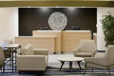 a waiting area with chairs and tables in a lobby at Fairfield Inn & Suites by Marriott Miami Airport South in Miami