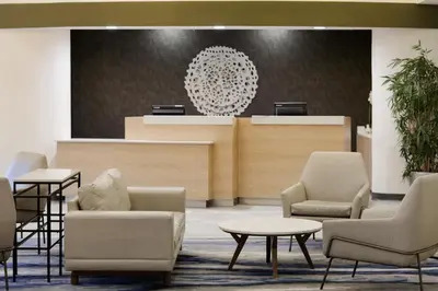 a waiting area with chairs and tables in a lobby at Fairfield Inn & Suites by Marriott Miami Airport South in Miami