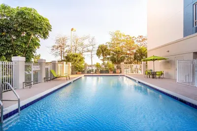 a swimming pool with tables and chairs next to a building at SpringHill Suites by Marriott Miami Airport South Blue Lagoon Area in Miami