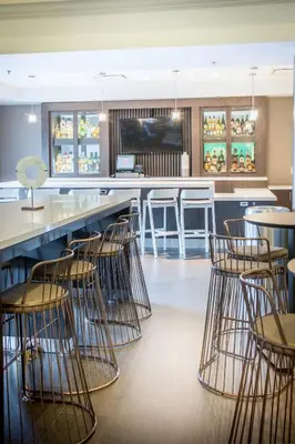 a bar with chairs and a counter in a restaurant at SpringHill Suites by Marriott Miami Airport South Blue Lagoon Area in Miami