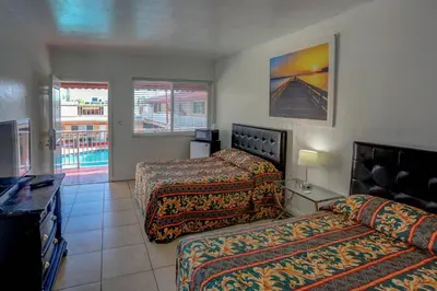 a hotel room with two beds and a balcony at Beach and Town Motel in Hollywood