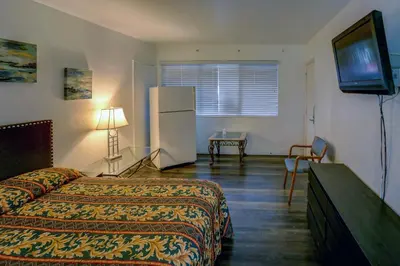 a hotel room with a bed and a refrigerator at Beach and Town Motel in Hollywood