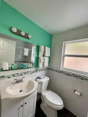 a bathroom with a white toilet and a sink at Nobleton Hotel in Fort Lauderdale