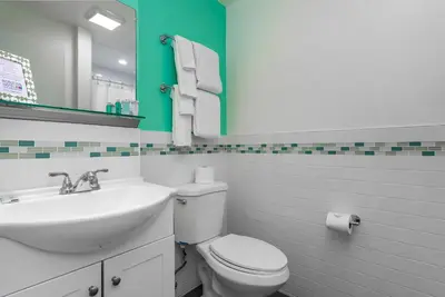 a bathroom with a sink and a toilet and a mirror at Nobleton Hotel in Fort Lauderdale