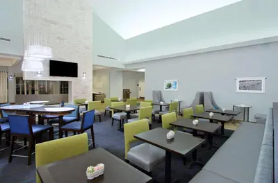 a dining room with tables and yellow chairs at Homewood Suites by Hilton Miami - Airport West in Miami