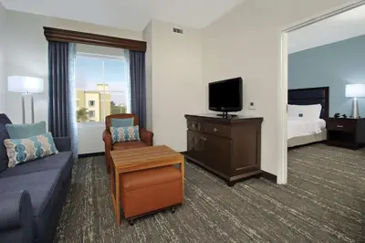 a hotel room with a couch and a tv at Homewood Suites by Hilton Miami - Airport West in Miami
