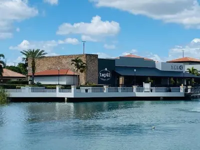 a building next to a body of water at The Palms Inn & Suites Miami, Kendall, FL in Kendall