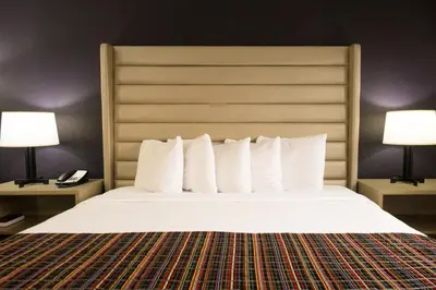 a hotel room with a large bed with two lamps at The Palms Inn & Suites Miami, Kendall, FL in Kendall