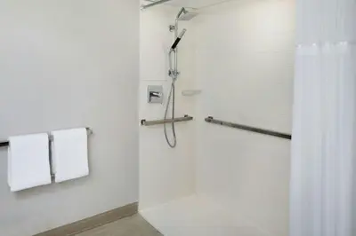 a white bathroom with a shower with white towels at Miami Airport Marriott in Miami
