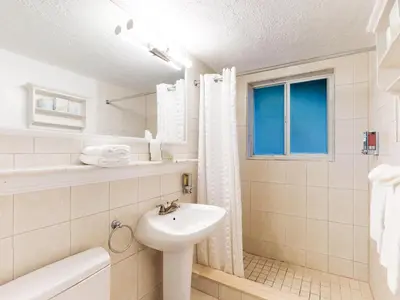 a white bathroom with a sink and a toilet at The Grand Resort and Spa & Worthington All Male in Fort Lauderdale