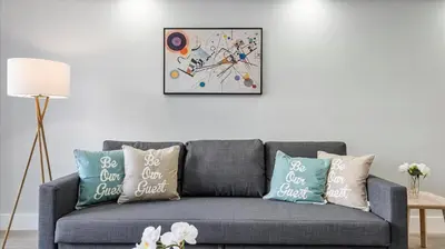 a living room with a gray couch with pillows at Family getaway in Sunny Isles - 2nd floor in Miami Beach