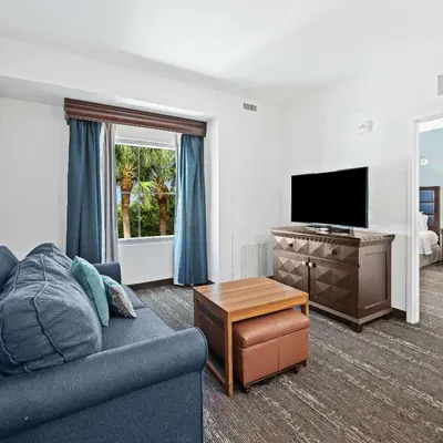 a living room with a couch and a flat screen tv at Homewood Suites by Hilton Fort Lauderdale Airport-Cruise Port in Dania Beach