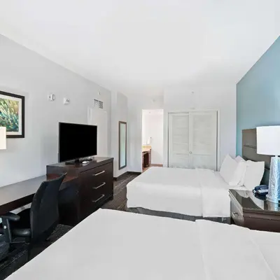 a hotel room with two beds and a desk and a television at Homewood Suites by Hilton Fort Lauderdale Airport-Cruise Port in Dania Beach