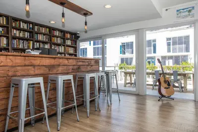 a room with a bar with a guitar and chairs at Premiere Hotel in Fort Lauderdale