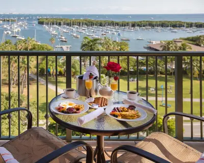 a table with breakfast food on a balcony with a harbor at The Mutiny Luxury Suites Hotel in Miami