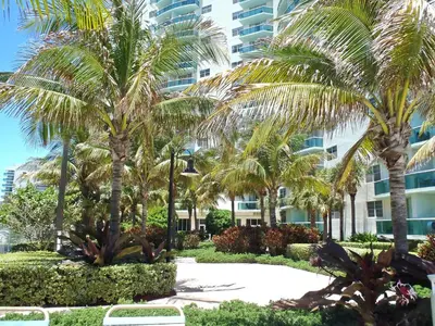 a resort with palm trees in front of a building at The Tides-1 bedroom apartment Ground Floor in Hollywood