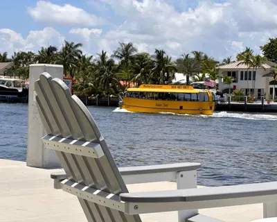a yellow boat in the water with a chair and a yellow bus at Holiday Isle Yacht Club in Fort Lauderdale